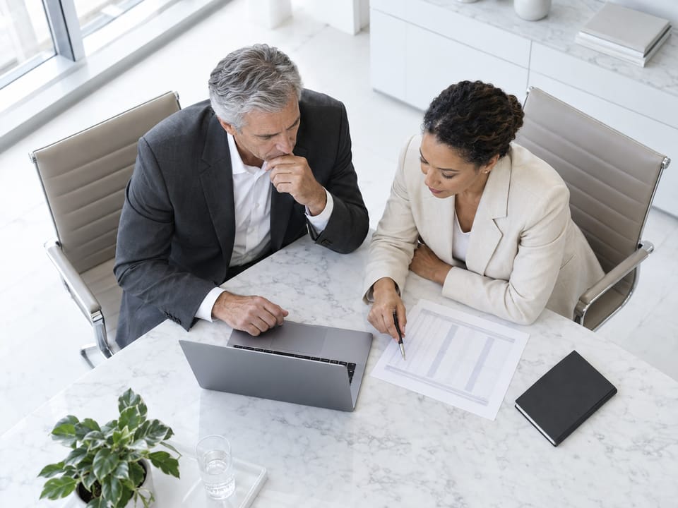Two executives in a quiet corner conversation